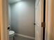 Modern powder room, featuring a sleek toilet and door at 227 Locust Rd, Ocala, FL 34472