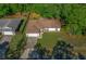 Aerial view of a single-story home with a two-car garage and mature trees surrounding the property at 2312 Sw 140Th Ct, Ocala, FL 34481
