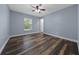 Cozy bedroom with a ceiling fan, wood-look floors and large window at 2312 Sw 140Th Ct, Ocala, FL 34481