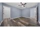 Bedroom with wood-look floors, ceiling fan, walk-in closet, and two doorways at 2312 Sw 140Th Ct, Ocala, FL 34481