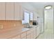 Well-lit kitchen featuring white appliances, light countertops, and ample storage with a view of the adjacent laundry room at 2339 Nw 55Th Avenue Rd, Ocala, FL 34482