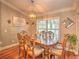 Formal dining room with hardwood floors, chandelier lighting, and a large window that offers a scenic outdoor view at 2410 Se 23Rd Pl, Ocala, FL 34471