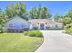 Charming single-story home with a well-manicured lawn and a curved driveway leading to the front entrance at 2410 Se 23Rd Pl, Ocala, FL 34471