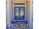 Charming home entrance with a double glass door framed by columns and decorated with vibrant potted flowers at 2410 Se 23Rd Pl, Ocala, FL 34471