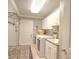 Well-equipped laundry room with white cabinets, washer, dryer, and sink at 2410 Se 23Rd Pl, Ocala, FL 34471
