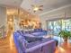 Open-concept living room with hardwood floors, blue sofa, and sliding glass doors to the backyard and outdoor spaces at 2410 Se 23Rd Pl, Ocala, FL 34471