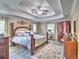 Luxurious main bedroom with tray ceilings, a sitting area, and a king-size bed with stylish bedding at 2410 Se 23Rd Pl, Ocala, FL 34471