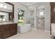 Bright bathroom featuring a soaking tub, walk-in shower, and granite countertops with a window view at 2515 Se 77Th St, Ocala, FL 34480