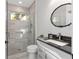 Contemporary bathroom with glass shower, marble tile, modern vanity, and a large round mirror at 2515 Se 77Th St, Ocala, FL 34480