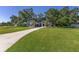 Well-manicured front yard showcasing beautiful landscaping, a long driveway, and a charming exterior with stone accents at 2515 Se 77Th St, Ocala, FL 34480