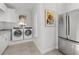 Bright laundry room featuring a washer, dryer, utility sink, and stainless steel refrigerator at 2515 Se 77Th St, Ocala, FL 34480