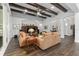 Spacious living room featuring beamed ceilings, hardwood floors, and an open layout with views of the kitchen and entryway at 2515 Se 77Th St, Ocala, FL 34480