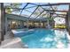 Screened pool with integrated spa features a tile surround and ample space for entertaining with views of the backyard at 2515 Se 77Th St, Ocala, FL 34480