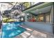 A screened pool area, featuring a pool, spa, and convenient access to the summer kitchen and bar at 2515 Se 77Th St, Ocala, FL 34480