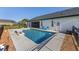 A fenced backyard features a pristine pool, chairs, a covered porch, and lush landscaping for a private oasis at 4083 Se 38Th Loop, Ocala, FL 34480