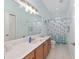 Bright bathroom with a big mirror, beautiful seashell-themed decor, and neutral tile flooring at 4083 Se 38Th Loop, Ocala, FL 34480