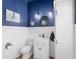 Charming half bathroom with blue accent wall, white wainscoting, and nautical themed decor at 4083 Se 38Th Loop, Ocala, FL 34480