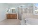 Bright bathroom featuring a corner shower, separate tub, and wooden cabinets at 4083 Se 38Th Loop, Ocala, FL 34480