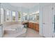 Bathroom with tub, dual sinks, natural light, and neutral color scheme at 4083 Se 38Th Loop, Ocala, FL 34480