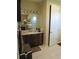 Well-lit bathroom featuring a granite countertop, dark wood cabinetry and a shower with glass doors at 4770 Sw 114Th St, Ocala, FL 34476