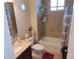 Well-lit bathroom features a shower-tub, tiled walls, granite countertop, and decorative accents at 4770 Sw 114Th St, Ocala, FL 34476