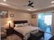 Spacious primary bedroom with a ceiling fan, a slider and neutral decor at 4770 Sw 114Th St, Ocala, FL 34476