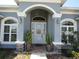 Elegant front entrance with arched windows, stone accents, and decorative plants at 4770 Sw 114Th St, Ocala, FL 34476