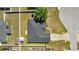 Aerial view of a home with a dark roof, fenced yard, and lush greenery at 4939 Sw 99Th Pl, Ocala, FL 34476