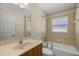 Traditional bathroom with a bathtub and shower combination, featuring neutral tile and a single sink vanity at 4939 Sw 99Th Pl, Ocala, FL 34476
