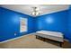 A cozy bedroom features vibrant blue walls, neutral carpet, and a modern ceiling fan with light fixture at 4939 Sw 99Th Pl, Ocala, FL 34476