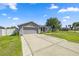 View of home's exterior showcasing a long driveway and well-maintained front yard at 4939 Sw 99Th Pl, Ocala, FL 34476