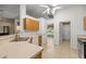 Open kitchen with wood cabinets, tile floors, and a view to the dining room at 4939 Sw 99Th Pl, Ocala, FL 34476