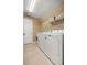 Well-organized laundry room features a washer, dryer, and shelving for ample storage at 4939 Sw 99Th Pl, Ocala, FL 34476
