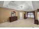 Spacious primary bedroom with a tray ceiling, neutral carpet, and backyard view at 4939 Sw 99Th Pl, Ocala, FL 34476