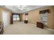 Large primary bedroom with a tray ceiling, fan, and comfortable carpet at 4939 Sw 99Th Pl, Ocala, FL 34476