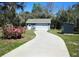 Detached garage with a driveway surrounded by greenery and a well-maintained yard at 5281 Sw 33Rd St, Ocala, FL 34474