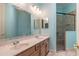 Light blue bathroom featuring double sinks with a glass enclosed shower with brown tiling at 6045 Ne 65Th St, Silver Springs, FL 34488