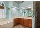 A bright bathroom featuring tile floors, a garden tub, wooden cabinetry and ample lighting at 6045 Ne 65Th St, Silver Springs, FL 34488