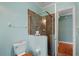 Light blue bathroom featuring a glass enclosed shower with brown tiling and wooden accents at 6045 Ne 65Th St, Silver Springs, FL 34488