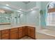 Bathroom with wooden cabinetry, tiled floors, and a garden tub at 6045 Ne 65Th St, Silver Springs, FL 34488