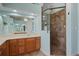 Well-lit bathroom featuring a tiled shower, vanity, and large mirror at 6045 Ne 65Th St, Silver Springs, FL 34488