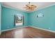 Bright bedroom with laminate wood flooring, two windows, and blue walls at 6045 Ne 65Th St, Silver Springs, FL 34488