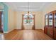 Bright dining room with wood floors, a chandelier, and a window providing ample natural light and garden views at 6045 Ne 65Th St, Silver Springs, FL 34488