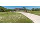 Long driveway leads to an attached garage on a home with solar panels at 6045 Ne 65Th St, Silver Springs, FL 34488