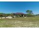 Beautiful one-story home with a well manicured lawn, mature landscaping, and an American flag at 6045 Ne 65Th St, Silver Springs, FL 34488