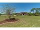 Landscaped front yard featuring a mature tree and providing a distant view of the home at 6045 Ne 65Th St, Silver Springs, FL 34488