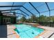 The sparkling pool has clear blue water, and is surrounded by brick pavers and a screened-in enclosure at 6045 Ne 65Th St, Silver Springs, FL 34488