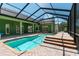 The sparkling pool has clear blue water, and is surrounded by brick pavers and a screened-in enclosure at 6045 Ne 65Th St, Silver Springs, FL 34488