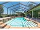 The sparkling pool has clear blue water, and is surrounded by brick pavers and a screened-in enclosure at 6045 Ne 65Th St, Silver Springs, FL 34488