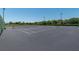 A black outdoor tennis court ready for a match, set on a sunny day under a clear blue sky at 6045 Ne 65Th St, Silver Springs, FL 34488
